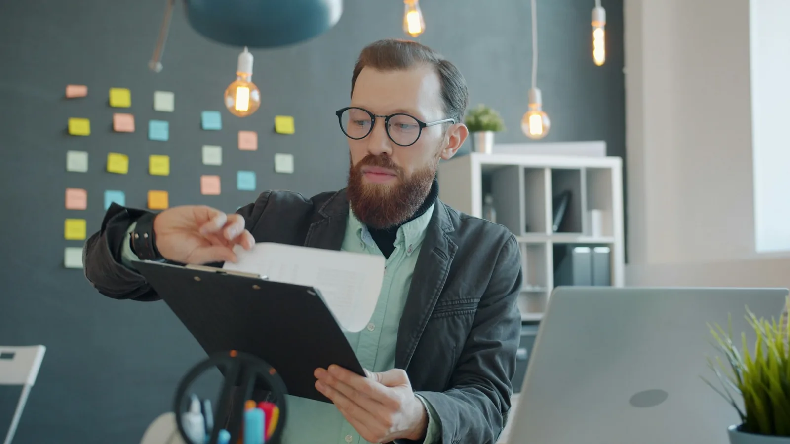 A person reading through printed documents at a desk