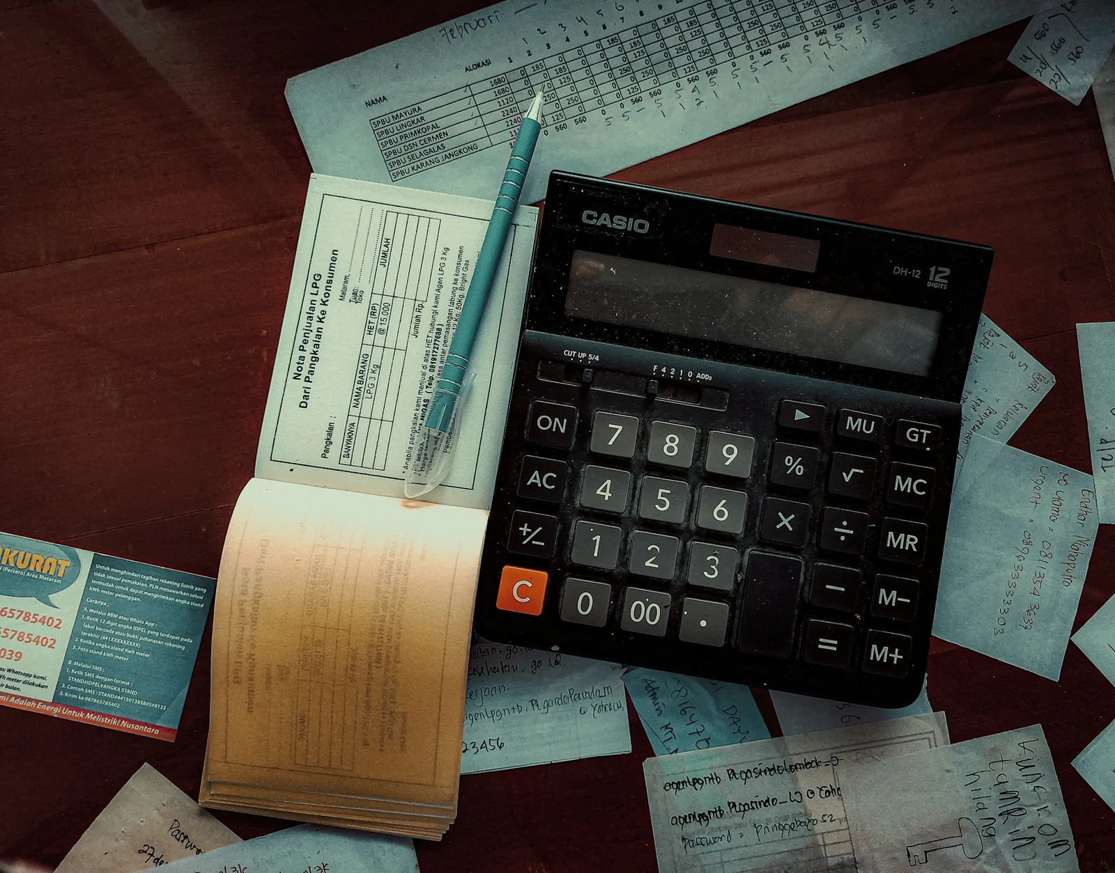 A calculator resting on a stack of bills on a desk