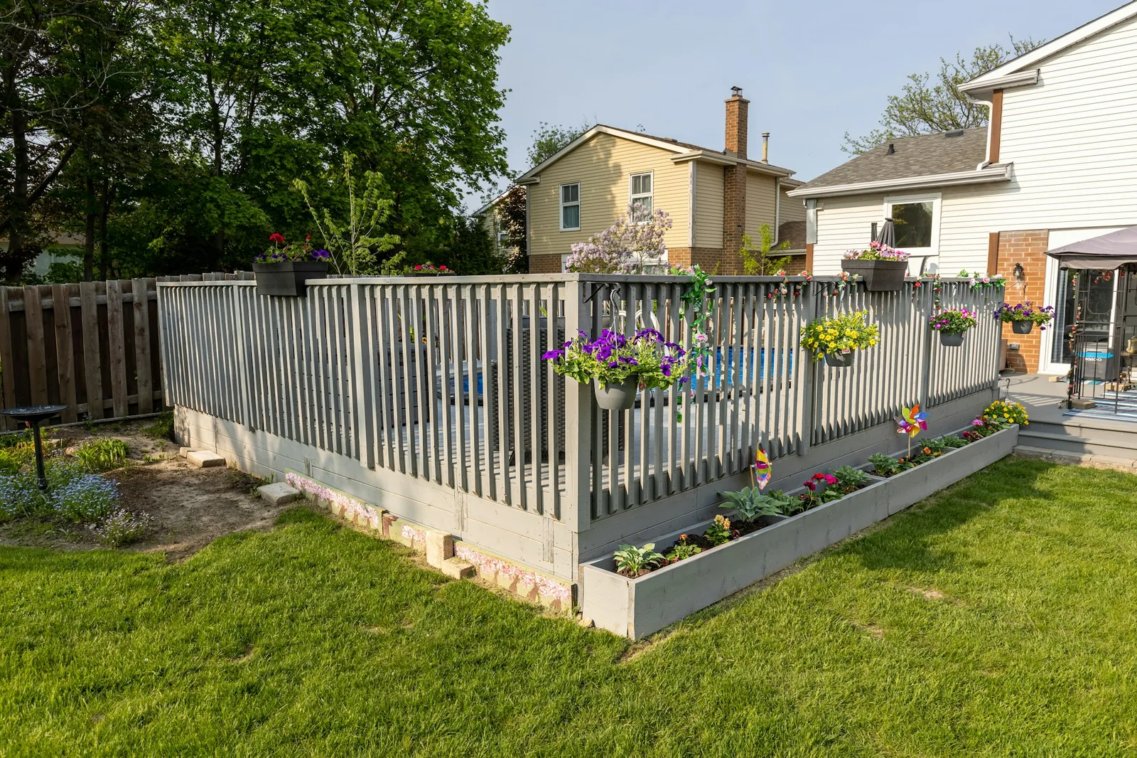 A fenced back garden with a gate and lawn