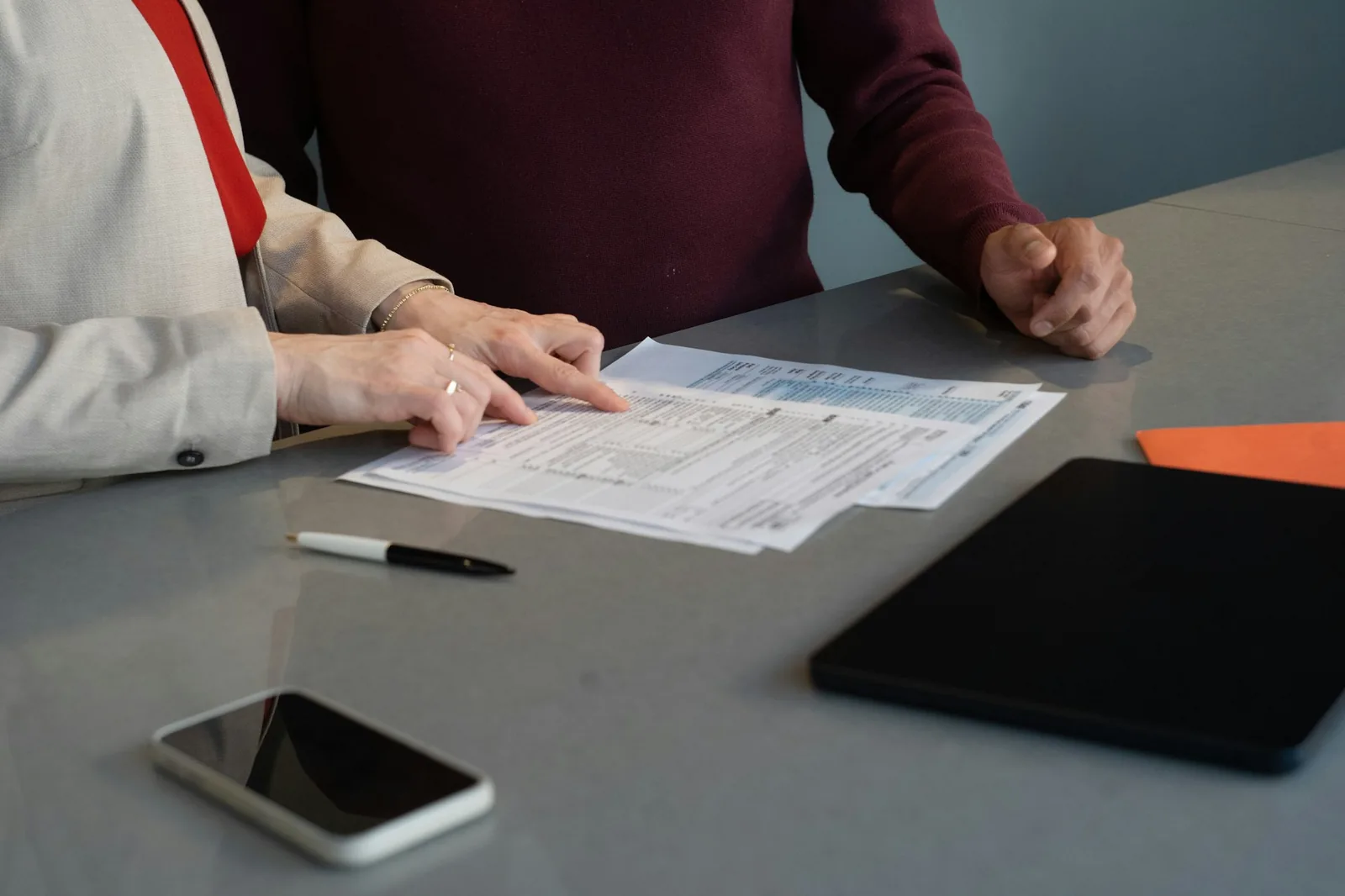 A person completing a paper form at a desk