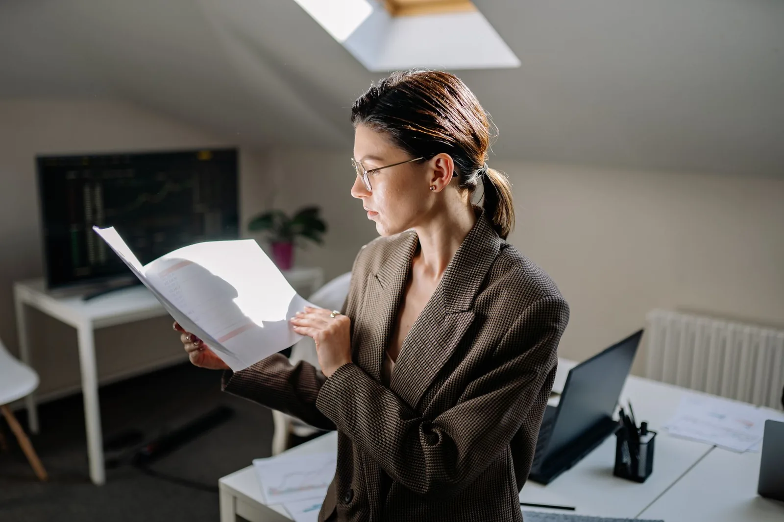 A person reviewing financial documents beside a laptop