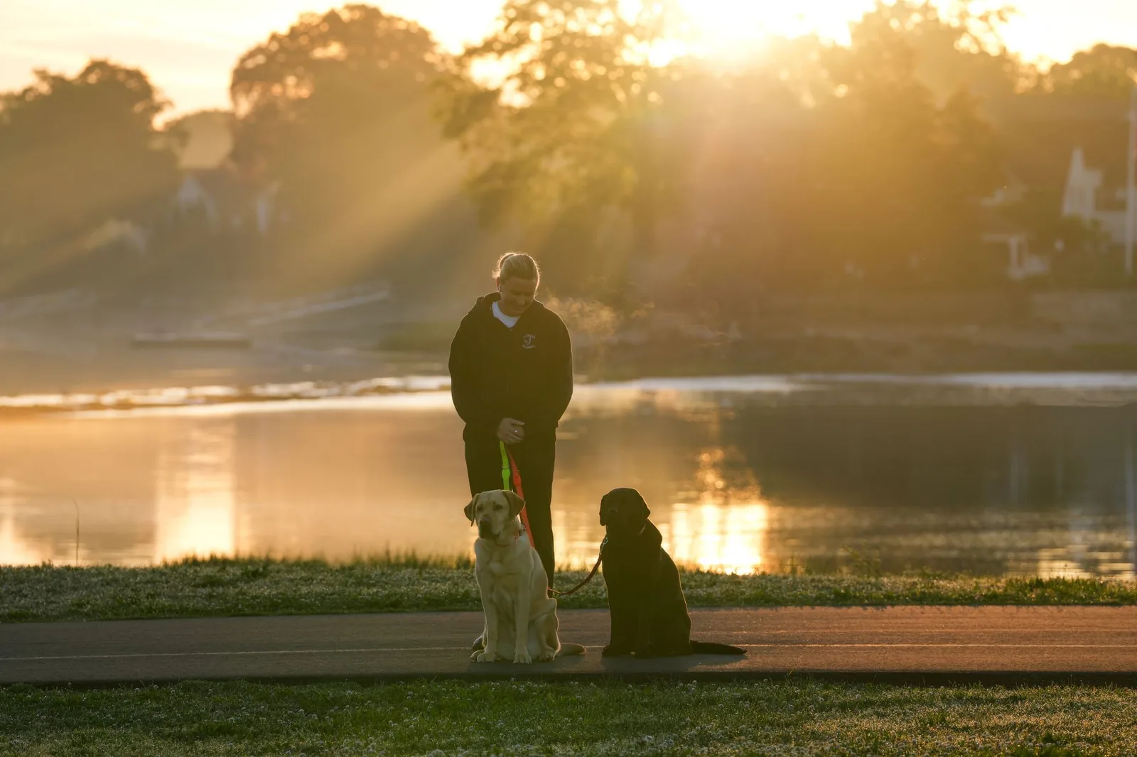A person walking a small dog early in the morning