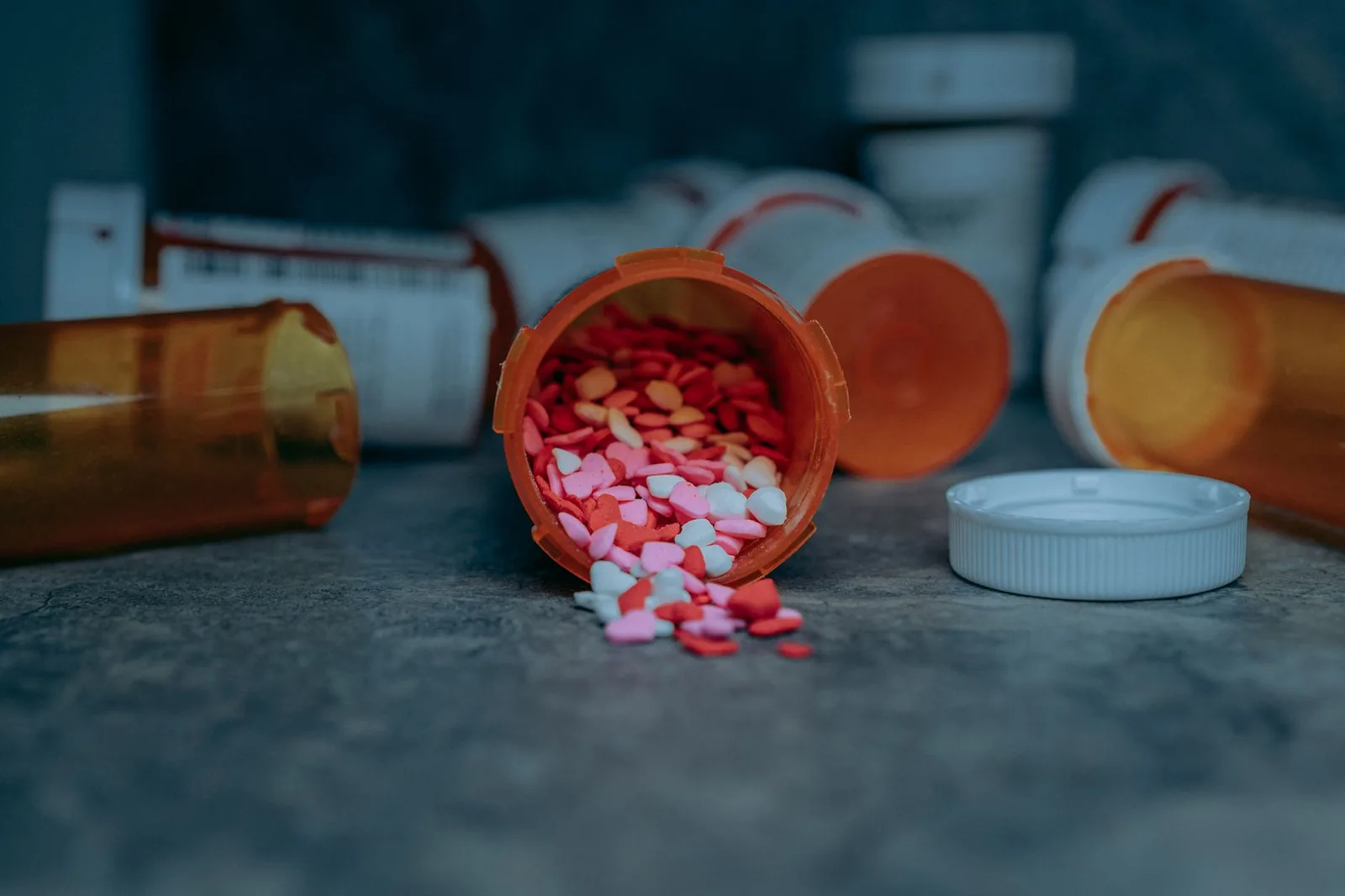 A dog resting near a table with medication bottles