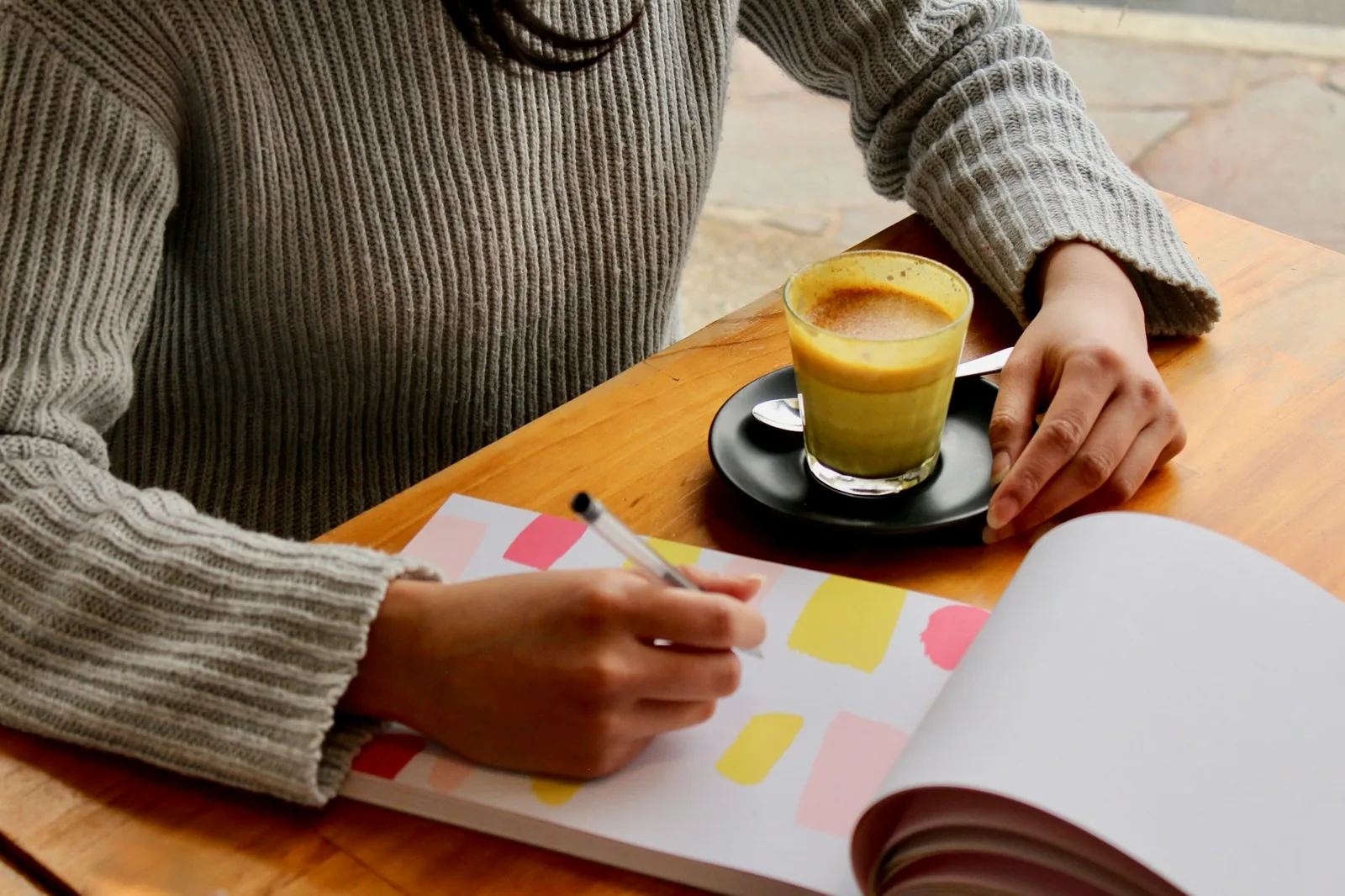 A person completing a written form at a kitchen table