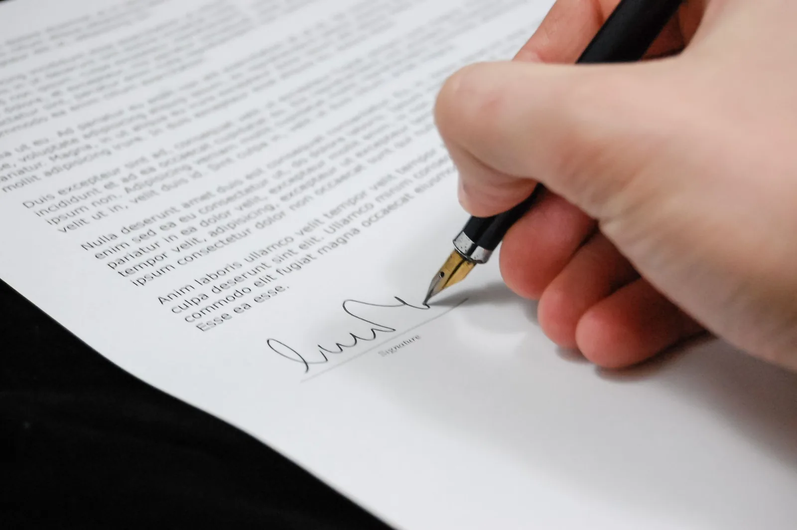 A contract being signed with a pen