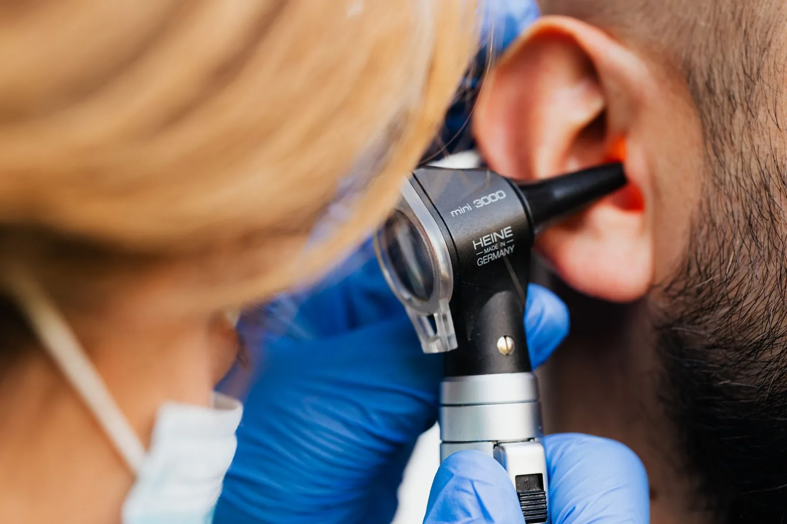 A veterinarian examining inside a dog’s ear with an otoscope