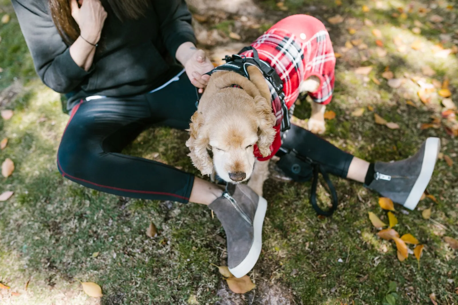 A person and a small dog sitting together outdoors
