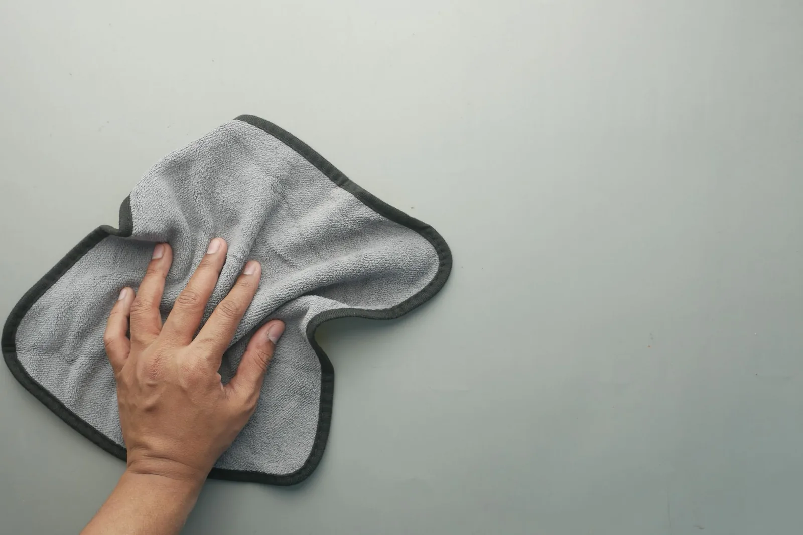 A dog’s face being wiped gently with a damp cloth